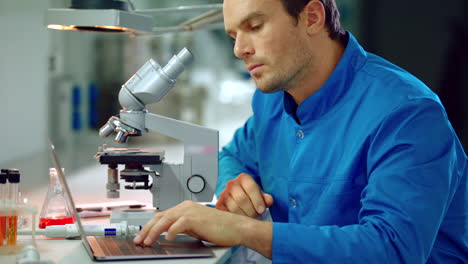 Male-scientist-looking-microscope-in-lab.-Microscope-laboratory-research